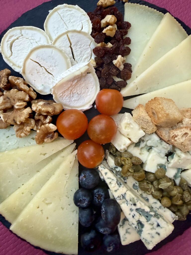 Tabla de quesos variados con nueces, pasas, tomates cherry y arándanos – Agencia Brilla.